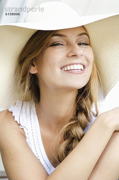 Lächelnde junge Frau mit Sonnenhut  Portrait