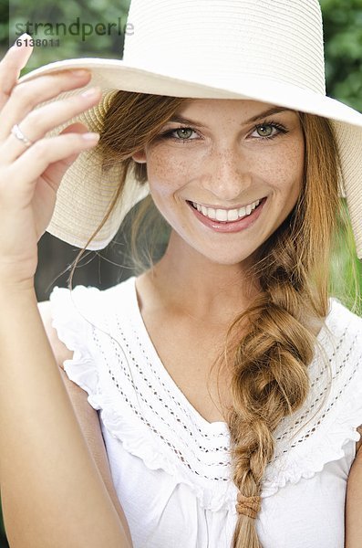 Lächelnde junge Frau mit Sonnenhut  Portrait