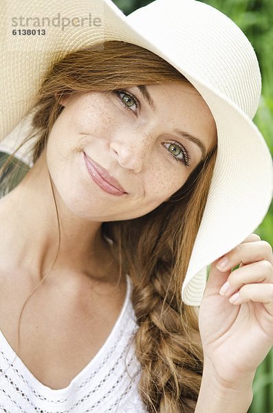 Lächelnde junge Frau mit Sonnenhut  Portrait