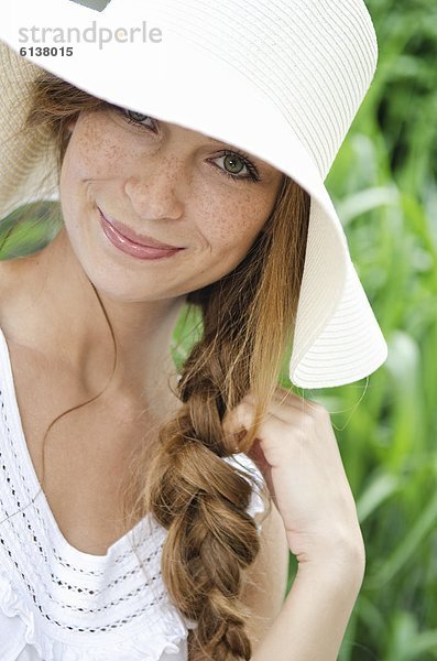 Lächelnde junge Frau mit Sonnenhut  Portrait