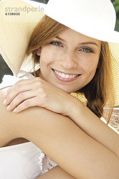 Lächelnde junge Frau mit Sonnenhut  Portrait