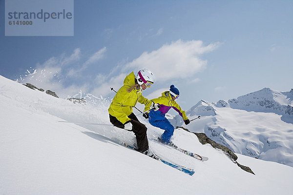 Skifahrer fahren auf verschneiter Piste