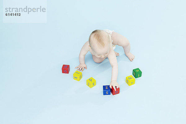 Baby Boy spielt mit farbigen Blöcken