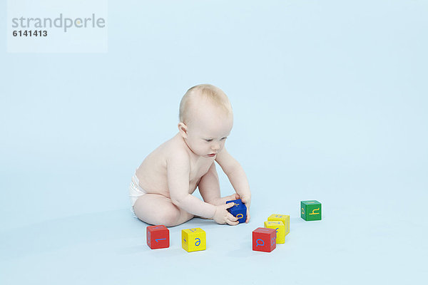 Baby Boy spielt mit farbigen Blöcken