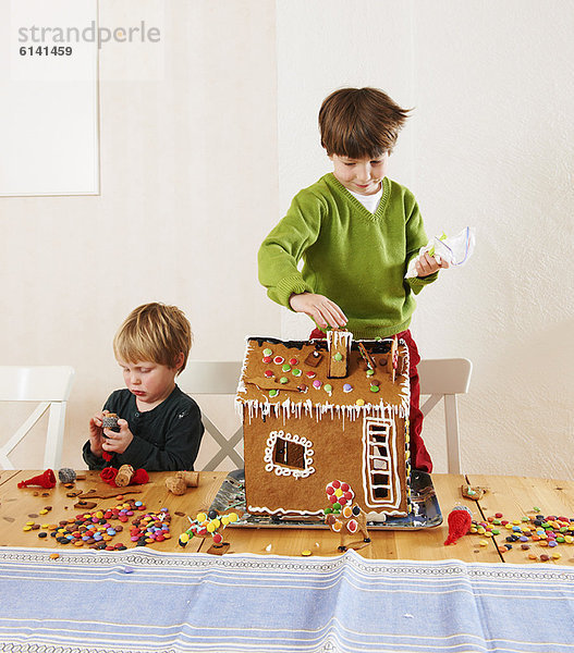 Lebkuchenhaus Junge - Person schmücken