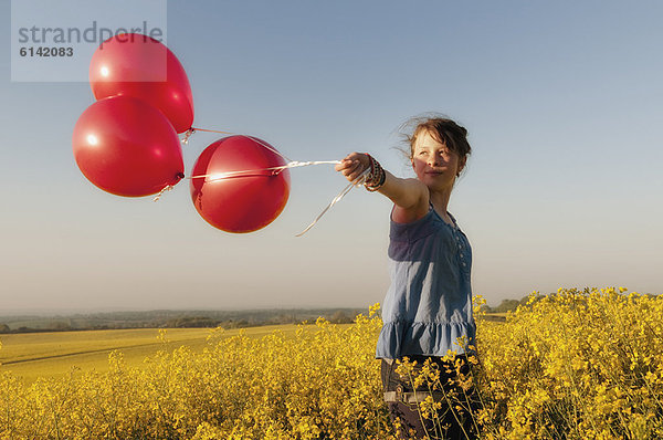 Mädchen mit Ballons im Feld