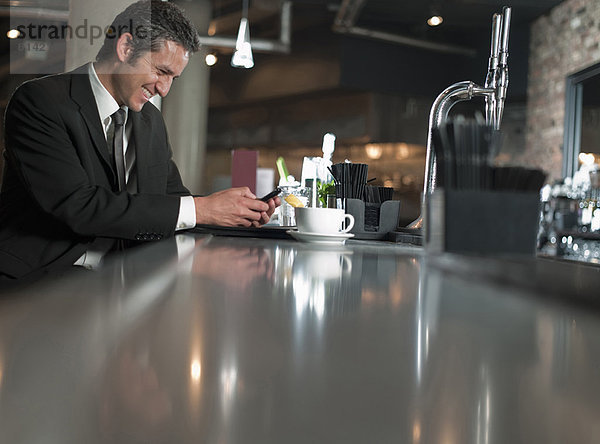 Geschäftsmann mit Handy im Café