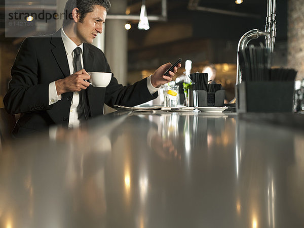 Geschäftsmann mit Handy im Café