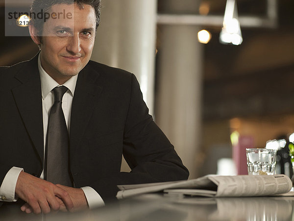 Geschäftsmann beim Zeitungslesen im Café