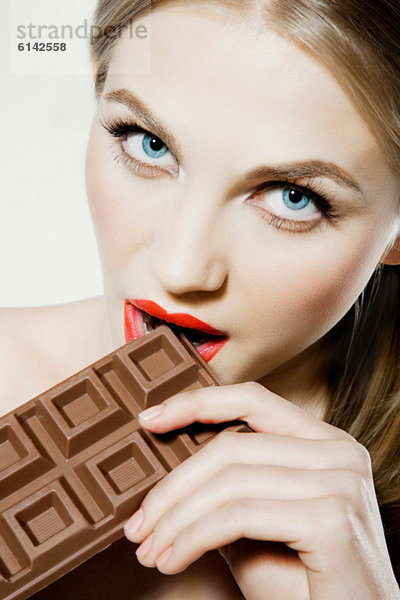 Junge Frau beißt Schokolade