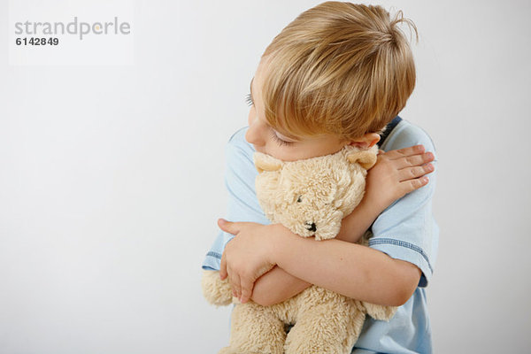 Junge umarmender Teddybär