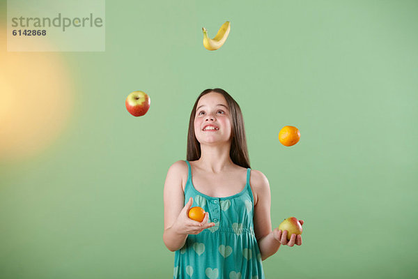 Mädchen jonglierende Früchte