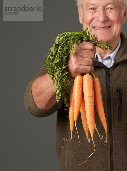Mann mit Karotten in der Hand