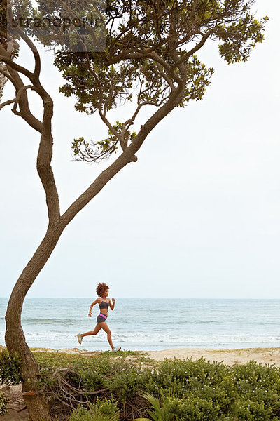 Junge Frau beim Joggen am Strand