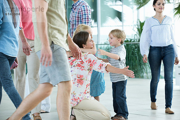 Mutter umarmt Kinder am Flughafen