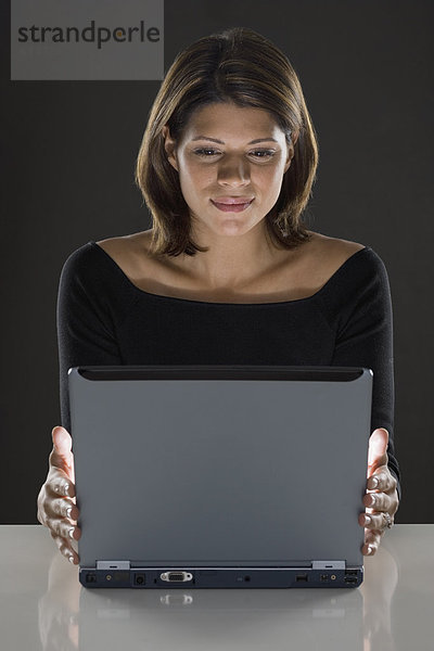 Frau sitzt vor Laptop