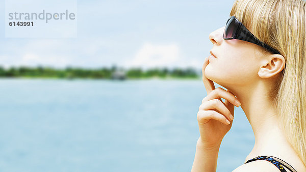 Entspannte  junge Frau mit Sonnenbrille mit Blick auf Insel der Malediven