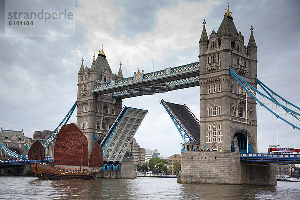 Chinesische Dschunke segelt durch die geöffnete Tower Bridge auf der Themse  London  England  Großbritannien  Europe