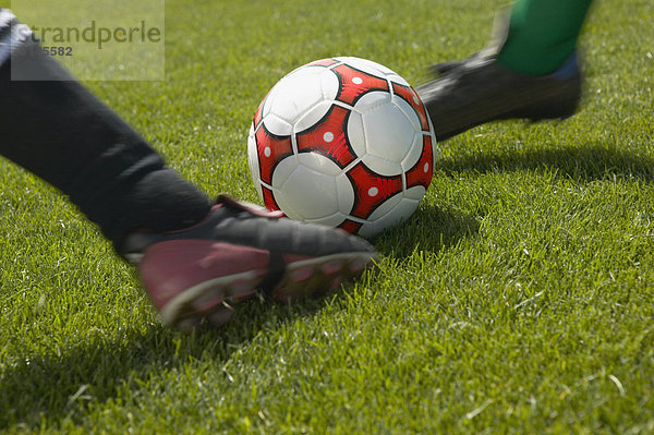 Fußballspieler treten Ball Spielzeug gleichzeitig