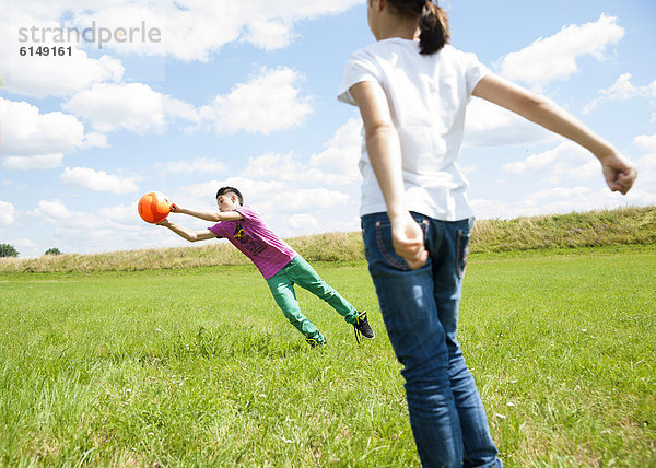 Zwei Kids spielen Fußball auf einer Wiese