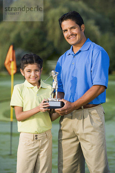 Menschlicher Vater  Hispanier  halten  Tochter  Golfsport  Golf  Pokal