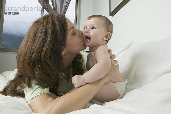 Hispanische Mutter kissing baby