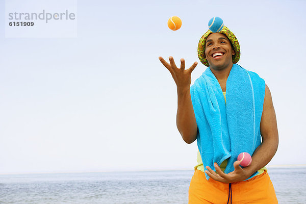 Mann  Strand  Hispanier  jonglieren