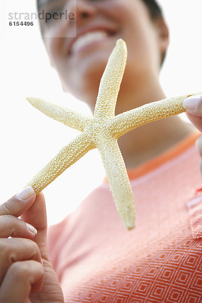 Frau hält starfish
