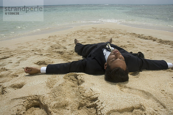 liegend liegen liegt liegendes liegender liegende daliegen Geschäftsmann Strand Hispanier