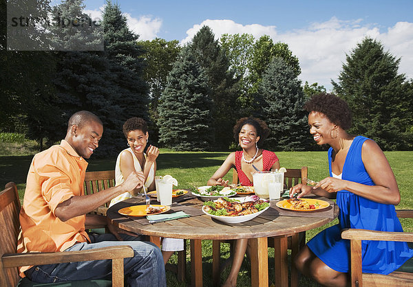 Außenaufnahme Freundschaft amerikanisch essen essend isst freie Natur
