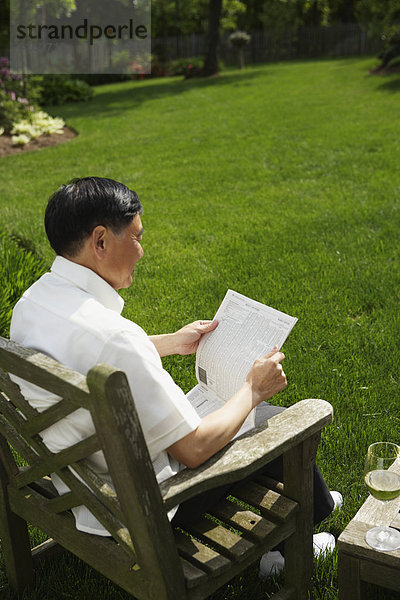 Senior Senioren Mann Garten Hinterhof vorlesen