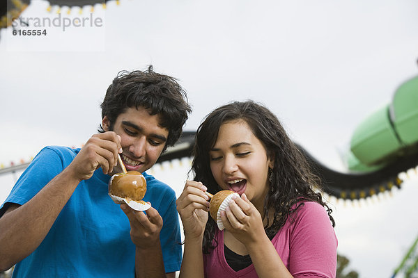 Glasierter Apfel  Glasierte Äpfel  kandierter  Liebesapfel  Apfel  multikulturell  essen  essend  isst  Jugendlicher