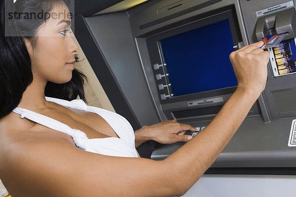 Hispanische Frau mit Geldautomaten