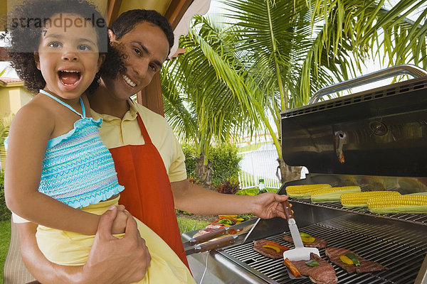 Menschlicher Vater  Hispanier  Tochter  grillen  grillend  grillt