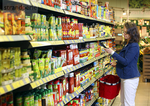 Frau kauft ein  Selbstbedienung  Lebensmittelabteilung  Supermarkt  Deutschland  Europa