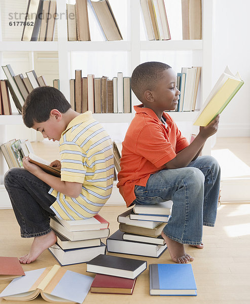 Stapel  sitzend  Buch  Junge - Person  vorlesen