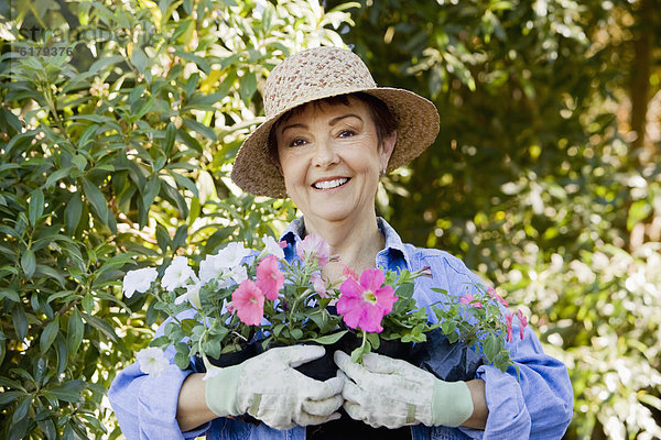 Frau Blume Hispanier halten Garten