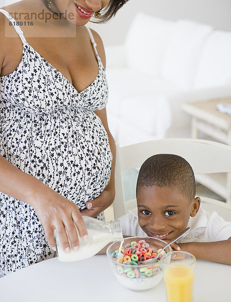 Getreide  lächeln  Junge - Person  eingießen  einschenken  schwarz  Schwangerschaft  Mutter - Mensch  Milch