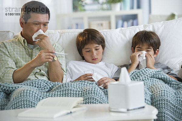 Prüfung Couch Menschlicher Vater Sohn blasen bläst blasend Zimmer Krankheit Temperatur Wohnzimmer