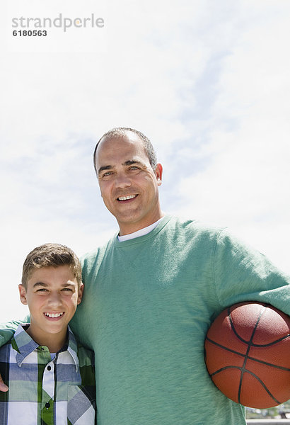 Hispanische Vater und Sohn mit basketball