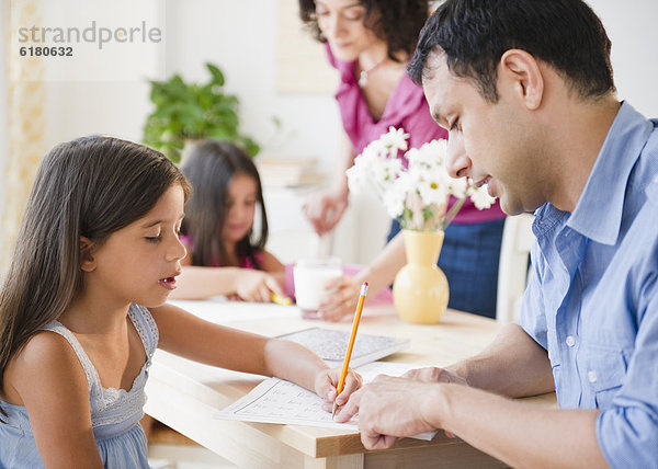 Kindern mit Hausaufgaben helfen Eltern