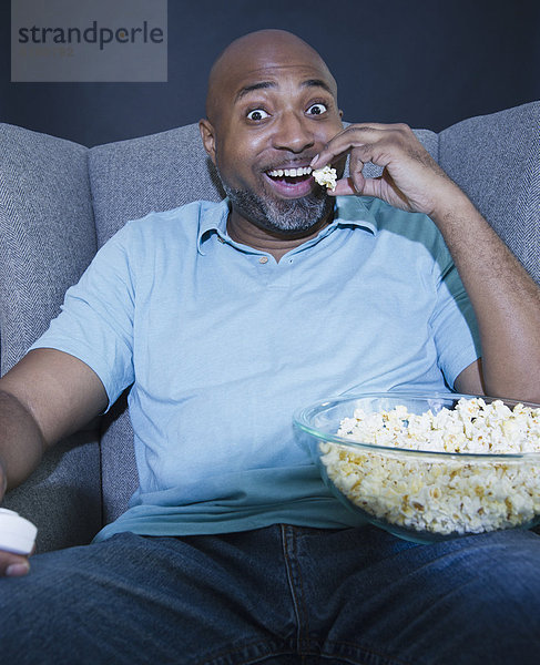 Mann sehen Fernsehen amerikanisch essen essend isst Popcorn