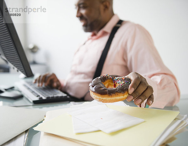 Schreibtisch  Geschäftsmann  amerikanisch  Donut  essen  essend  isst