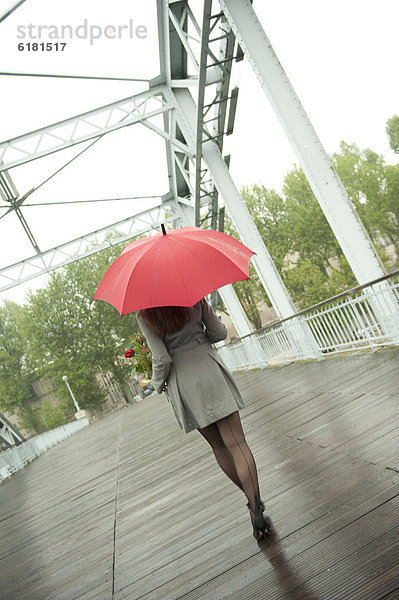 Europäer  Frau  gehen  Regenschirm  Schirm  Regen  rot