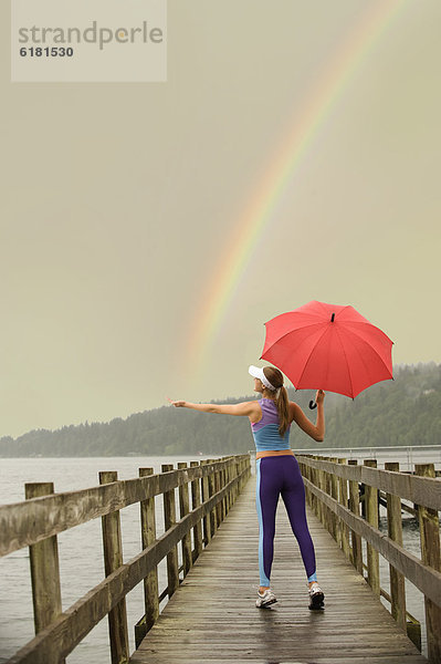 Europäer  Frau  fangen  Regenschirm  Schirm  Sportkleidung  Kai  rot  Regenbogen