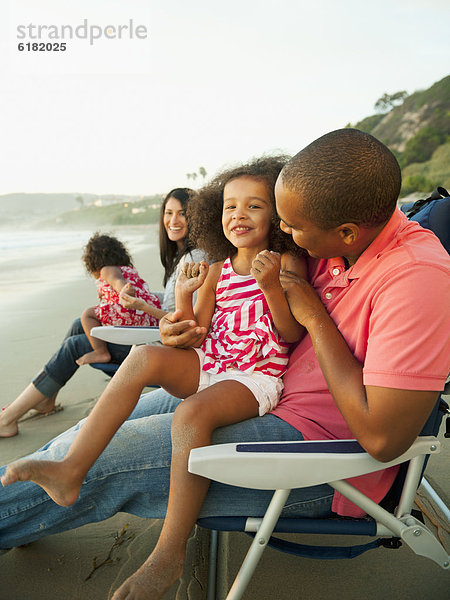 Familie zusammensitzen am Strand