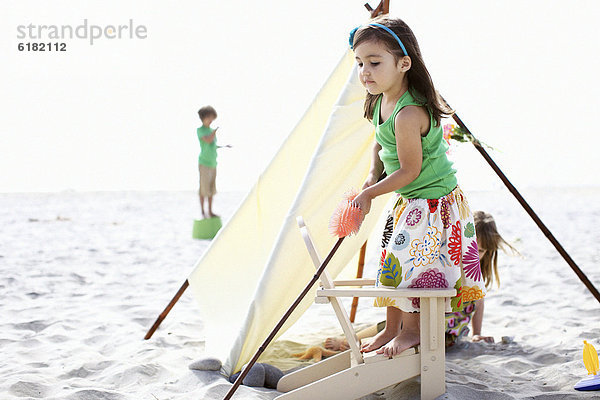 Kinder spielen am Strand