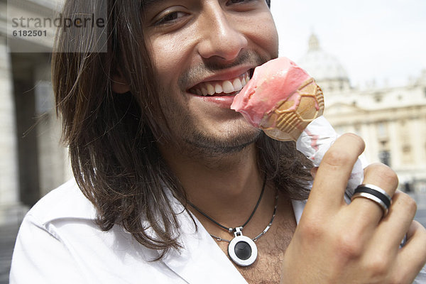 kegelförmig  Kegel  Mann  Eis  essen  essend  isst  Sahne  Italienisch