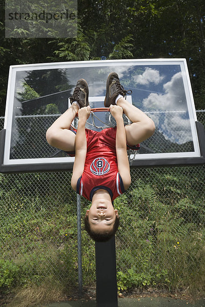 Junge - Person  hängen  Basketball  kopfüber  einlochen