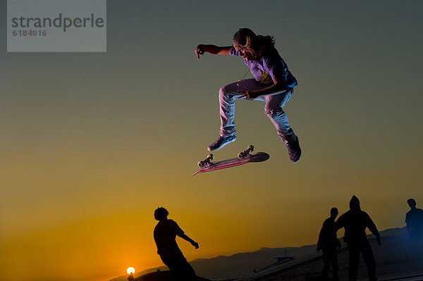 Europäer  In der Luft schwebend  Sonnenuntergang  Stunt  Skateboarder